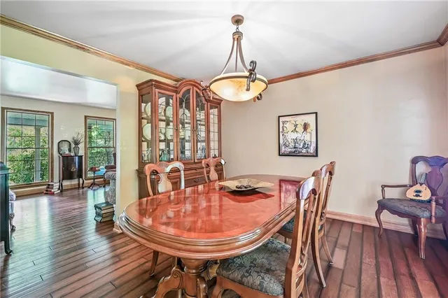 a dining room with furniture a chandelier and wooden floor