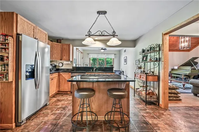 a kitchen with a refrigerator a stove a sink and a dining table with chairs