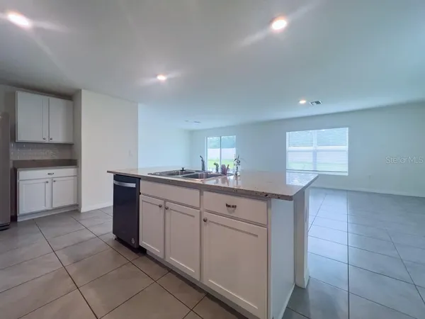 a view of a kitchen with kitchen island refrigerator sink and stove