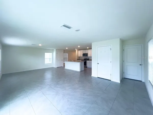 a large kitchen with kitchen island a counter top space a sink a stove a refrigerator and a window