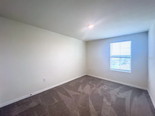 a view of an empty room and closet area