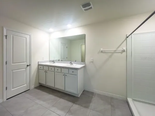 a spacious bathroom with a granite countertop sink a mirror and a