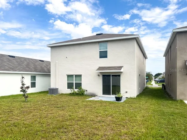 a view of a house with backyard porch and furniture