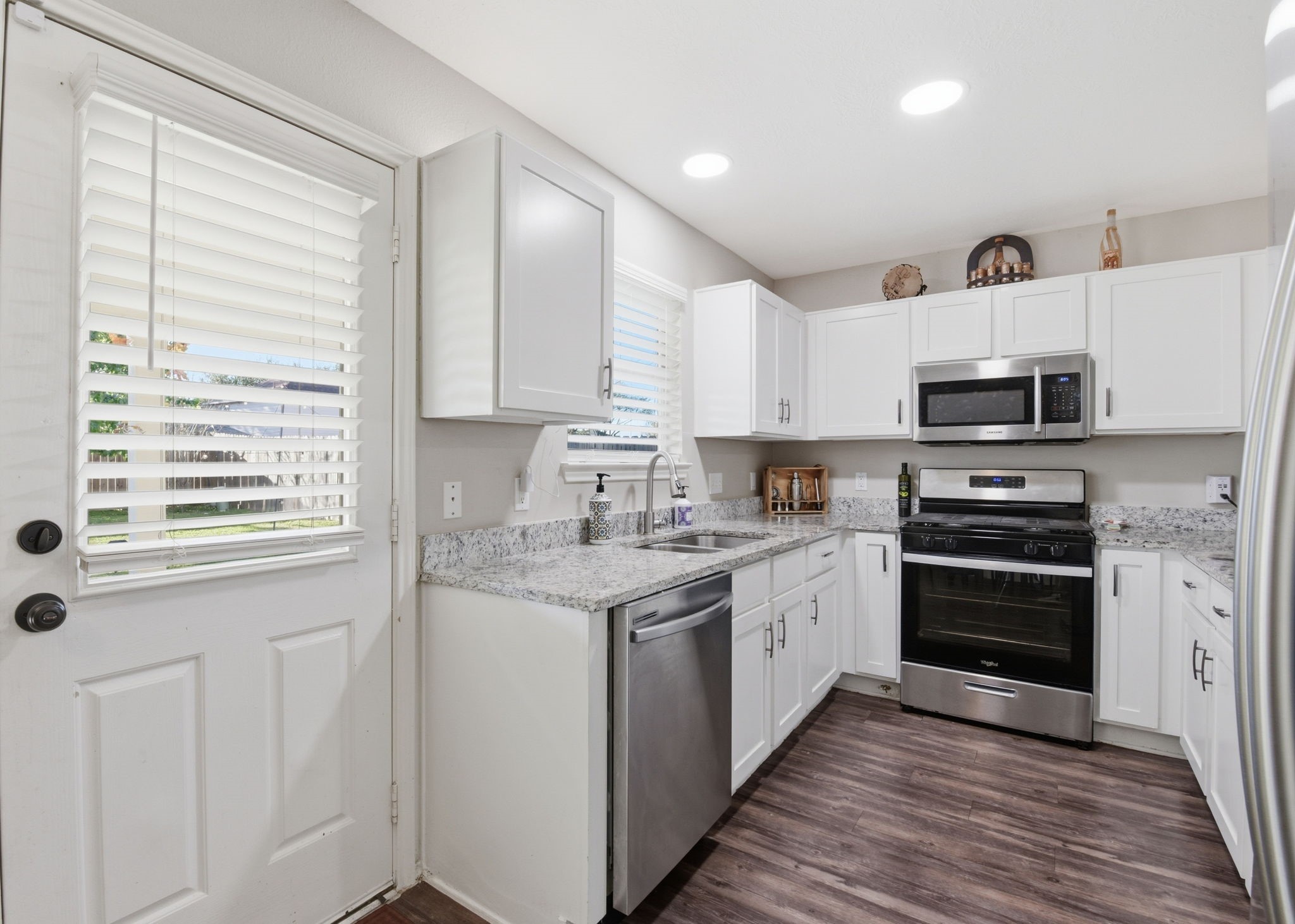 9519 Maple Green Lane Houston, TX 77044 - Photo 11 of 50 a kitchen with stainless steel appliances granite countertop a stove and a sink