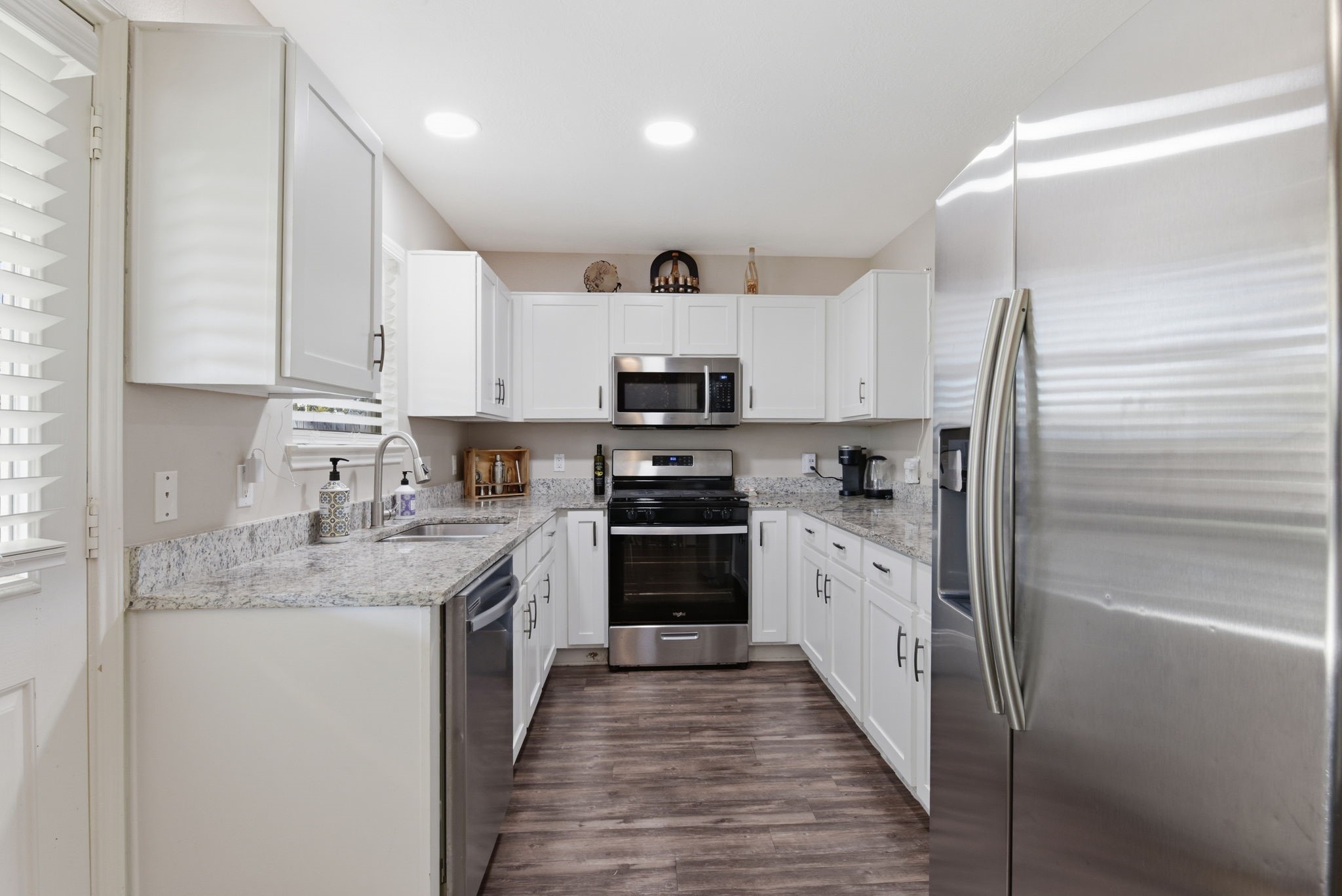9519 Maple Green Lane Houston, TX 77044 - Photo 19 of 50 a kitchen with granite countertop a sink stainless steel appliances and white cabinets