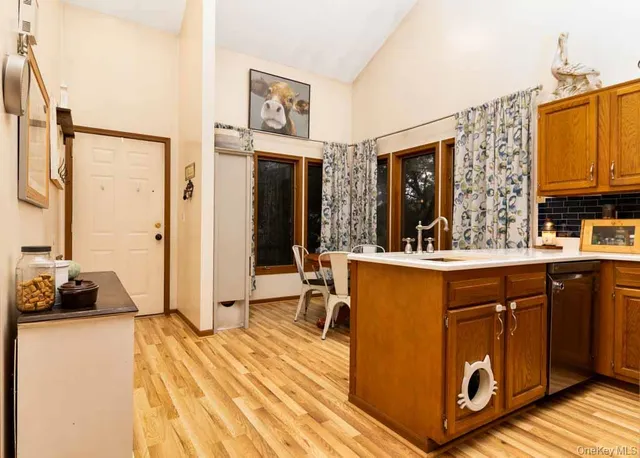 a kitchen with stainless steel appliances granite countertop a refrigerator a stove and a sink with wooden floor