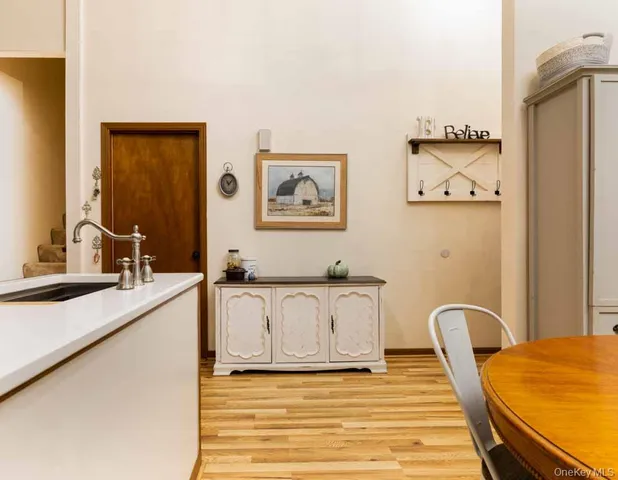a view of a kitchen with a sink wooden cabinets and a large window