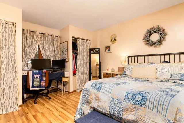 a bedroom with a bed a couch and a window