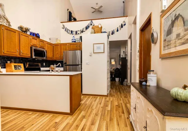 a kitchen with stainless steel appliances granite countertop a refrigerator a stove and a wooden floor