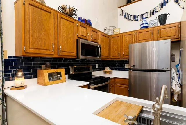 a kitchen with stainless steel appliances wooden cabinets a refrigerator and a sink