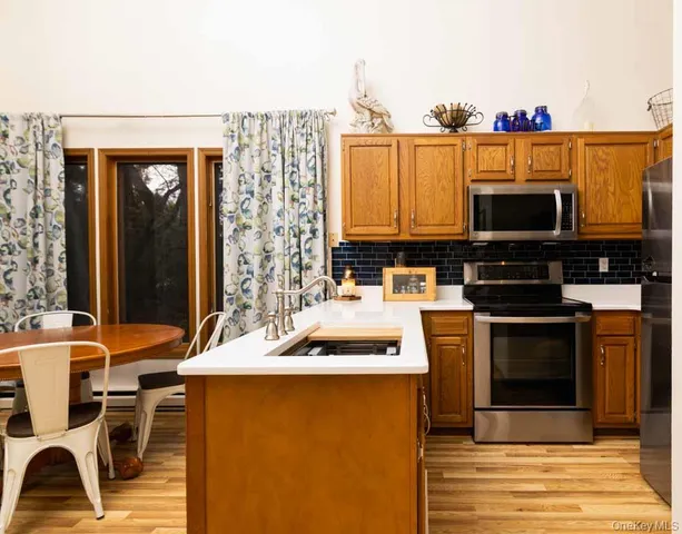 a kitchen with stainless steel appliances a stove a sink and a microwave