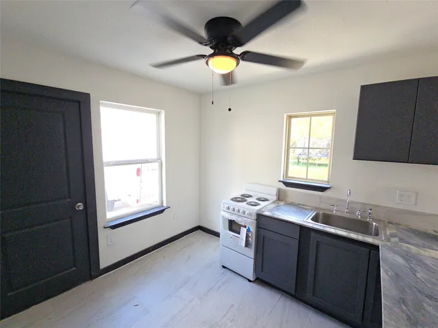 a kitchen with a stove a sink and a window