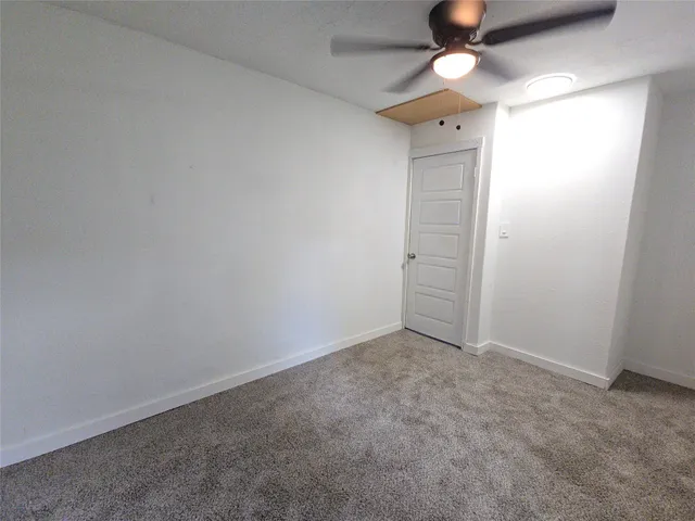 an empty room with closet and a chandelier fan