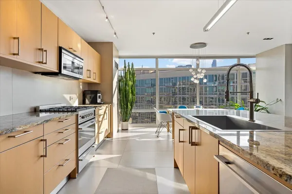a kitchen with granite countertop a sink and a large window
