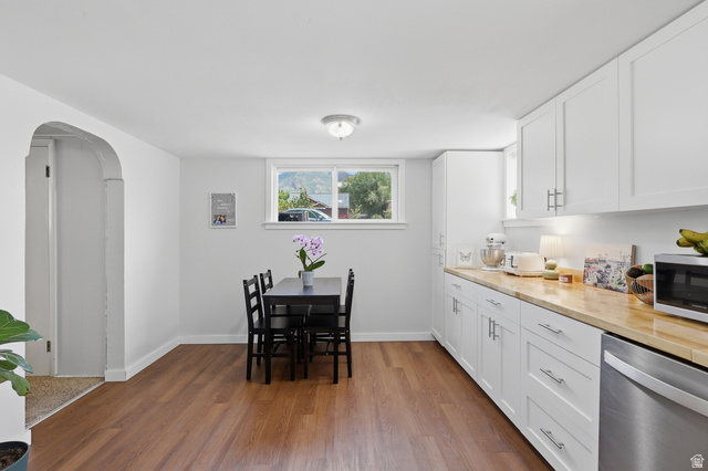 85 North 800 West Provo, UT 84601 - Photo 17 of 25 Bright kitchen space featuring wood-finish flooring, white cabinetry with silver-tone hardware, wood-finish countertops, an undermount sink, and a stainless steel dishwasher