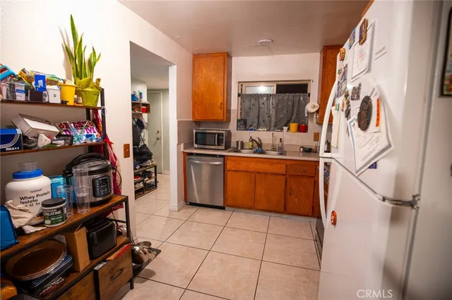 a kitchen with stainless steel appliances a stove a refrigerator a sink a counter space and cabinets