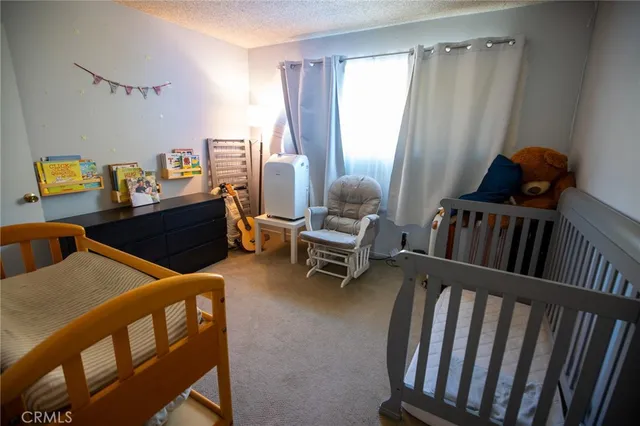 a view of a bedroom with baby bed and furniture