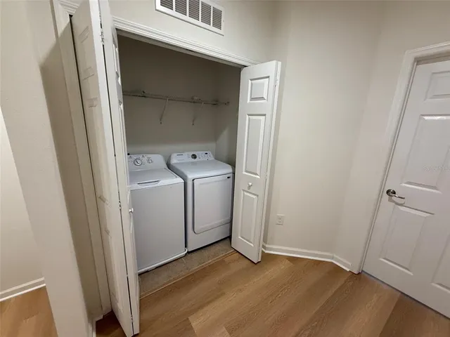a view of a utility room with closet and wooden floor