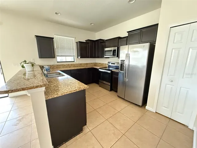 a kitchen with granite countertop a refrigerator and a sink