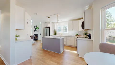 a kitchen with sink a refrigerator and wooden floor