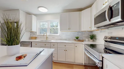 a kitchen with stainless steel appliances white cabinets and a sink