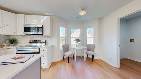 a kitchen with stainless steel appliances a stove a sink dishwasher and microwave with wooden floor