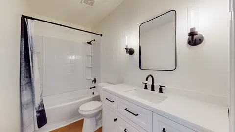a bathroom with a sink a toilet and shower