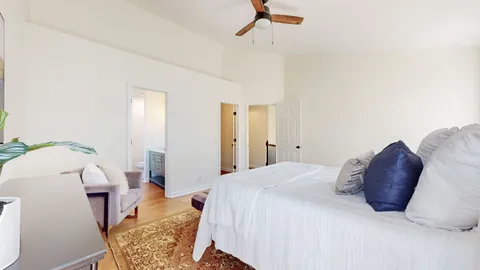 a spacious bedroom with a bed and a chandelier