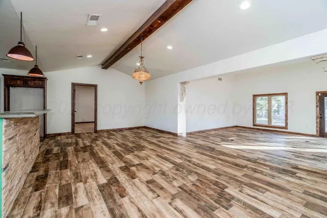 a view of an empty room with a fireplace and a window
