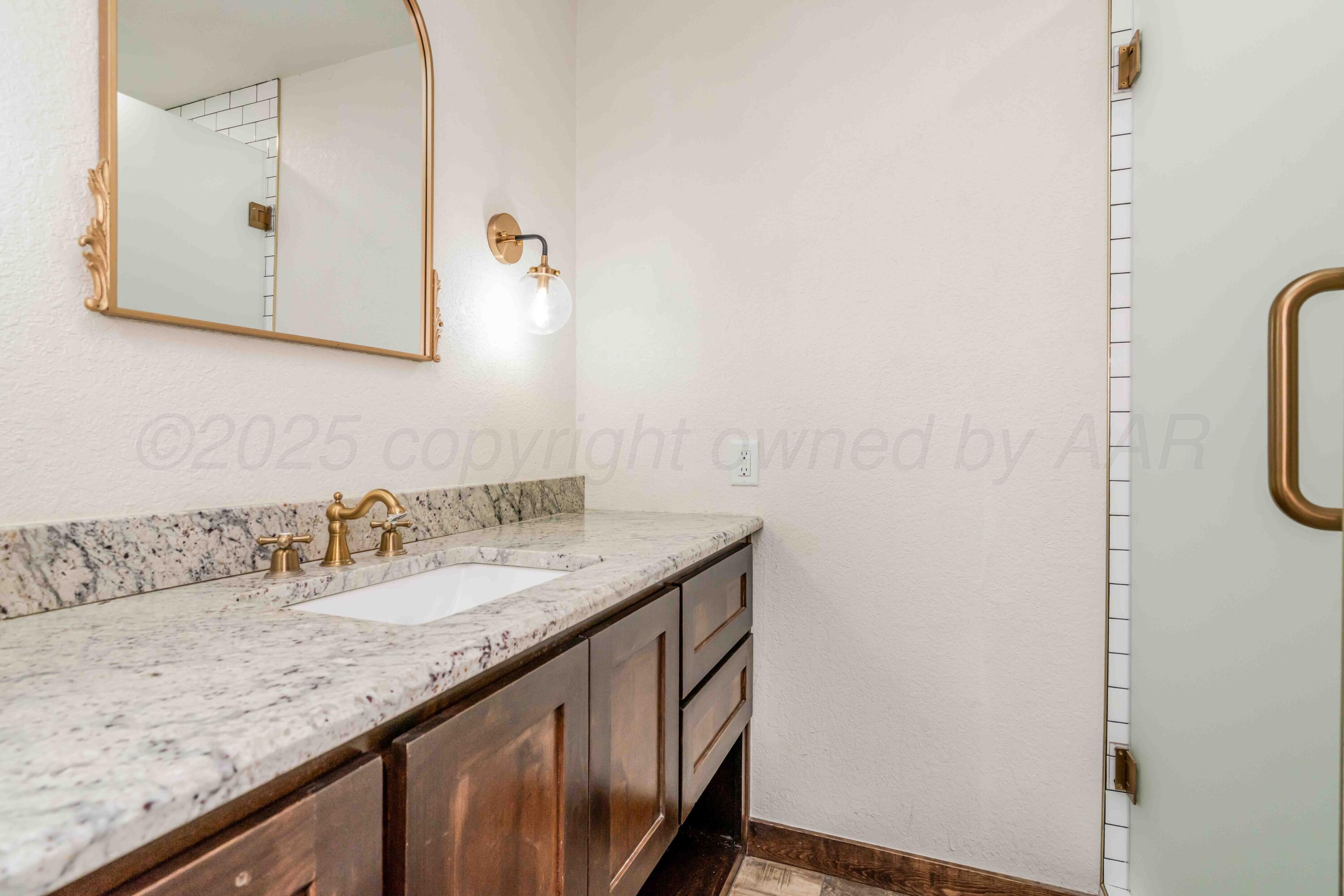 5490 West Rd R Dumas, TX 79029 - Photo 25 of 36 a bathroom with a granite countertop sink and a mirror