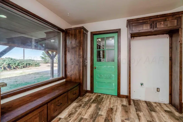 a view of a room that has a large window and a wooden floor