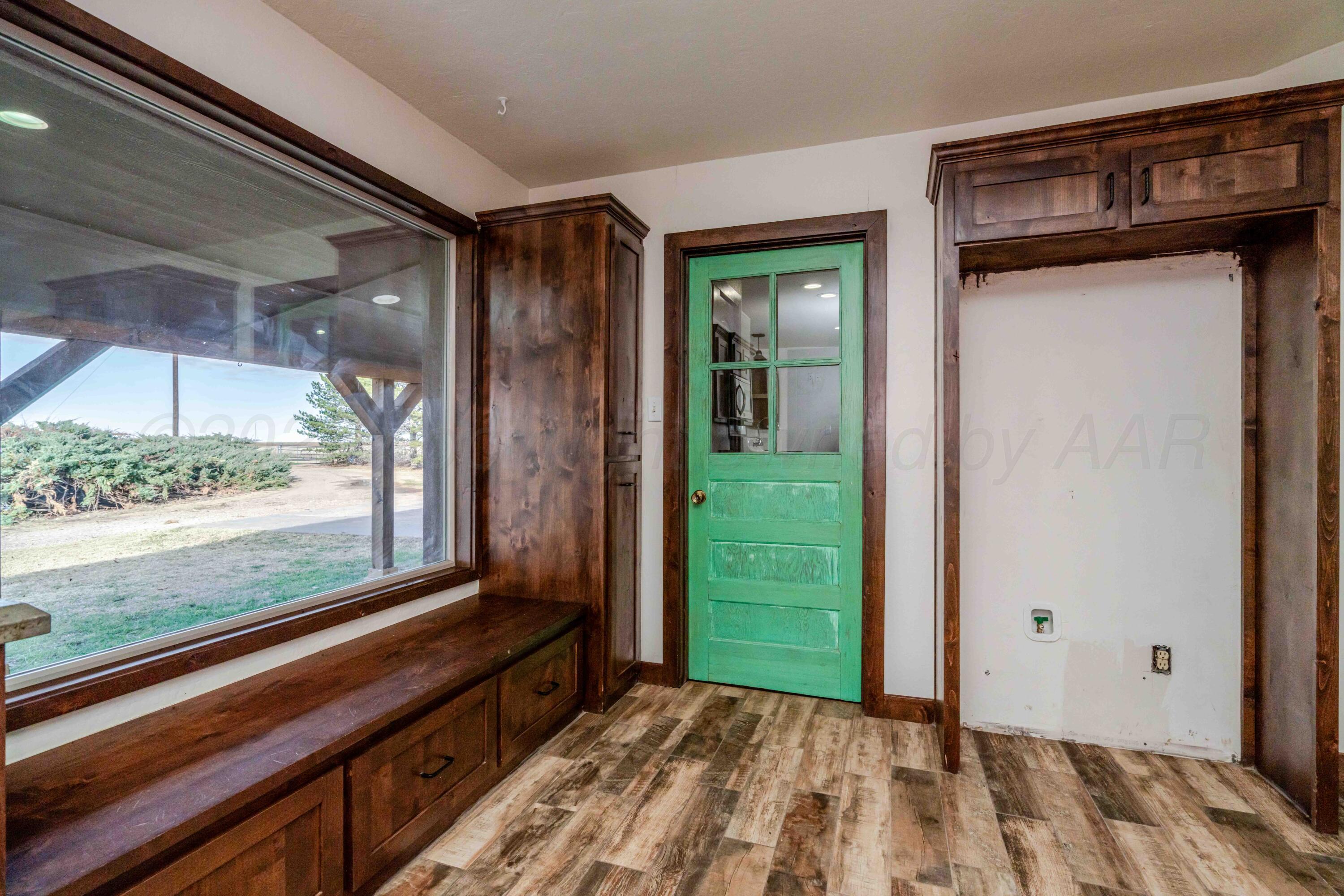 5490 West Rd R Dumas, TX 79029 - Photo 8 of 36 a view of a room that has a large window and a wooden floor