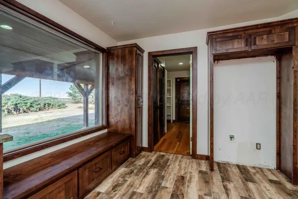 a view of a hallway with wooden floor and a bathroom