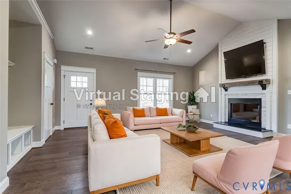 a view of an empty room with chandelier fan and fire place