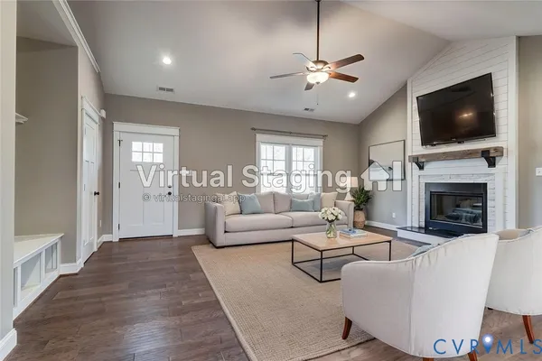 an empty room with wooden floor fireplace and windows