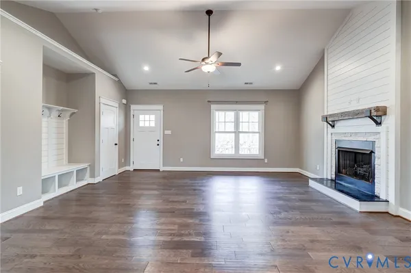 a view of an empty room with a window and wooden floor