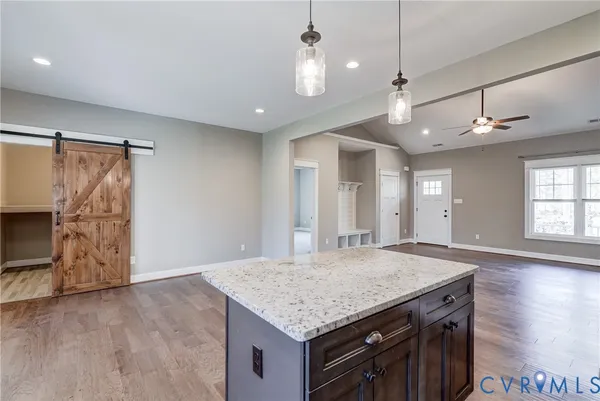 a large kitchen with stainless steel appliances granite countertop a stove a sink dishwasher a microwave oven with cabinets and wooden floor