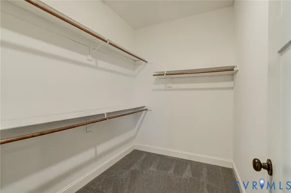a view of an empty room with a chandelier fan