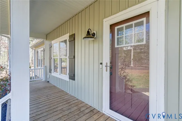 a view of a porch with wooden floor and front door
