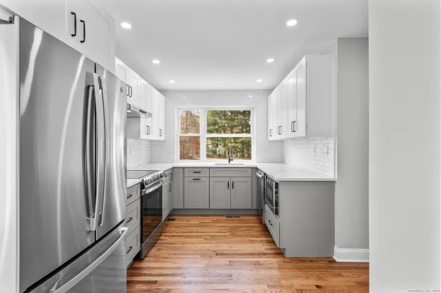 a view of empty room with wooden floor and windows
