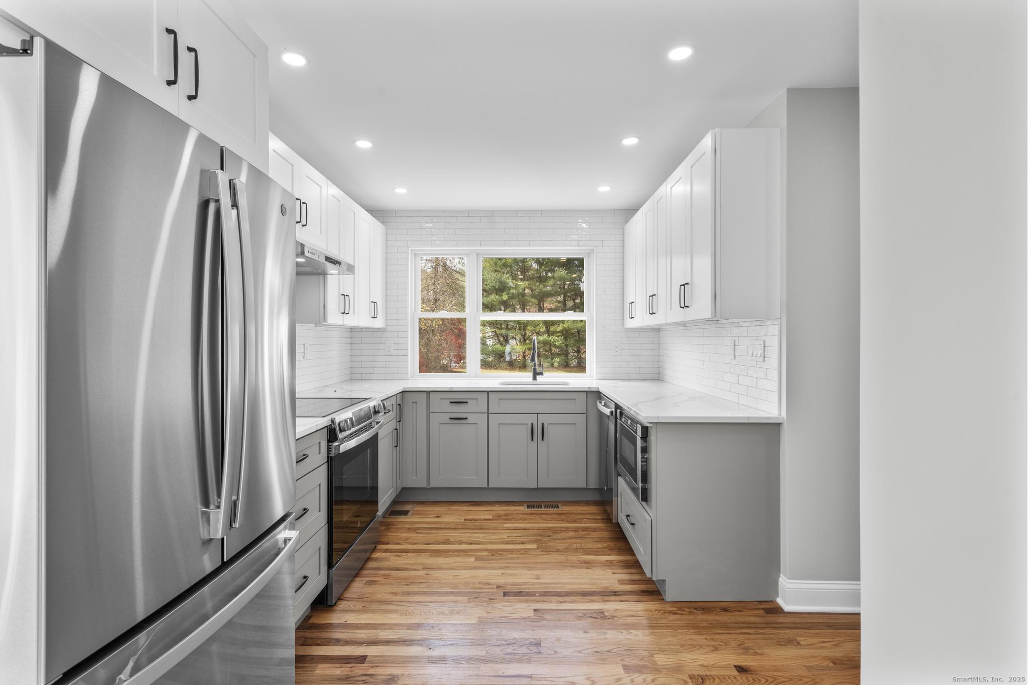 1092 Durham Road Guilford, CT 06437 - Photo 6 of 38 a kitchen with sink a refrigerator and white cabinets