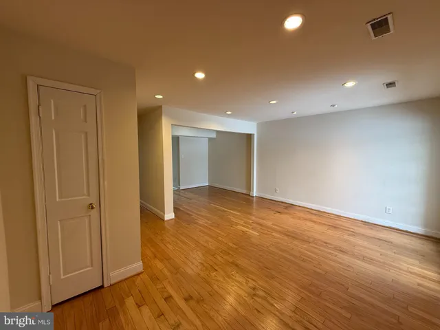 a view of an empty room with wooden floor