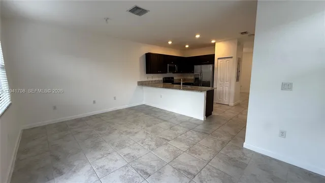 a view of a kitchen with a sink and a refrigerator