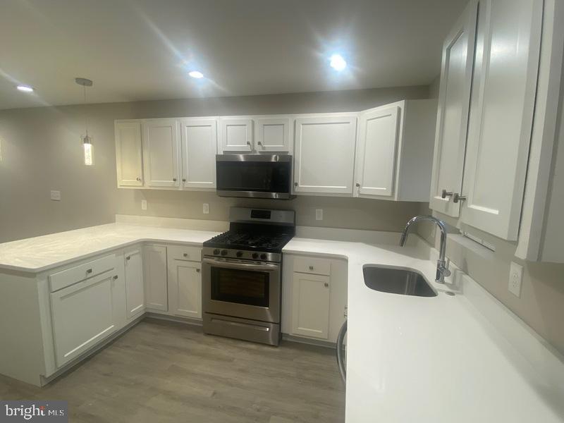 224 North Rose Street Baltimore, MD 21224 - Photo 2 of 14 a kitchen with a sink stove and cabinets