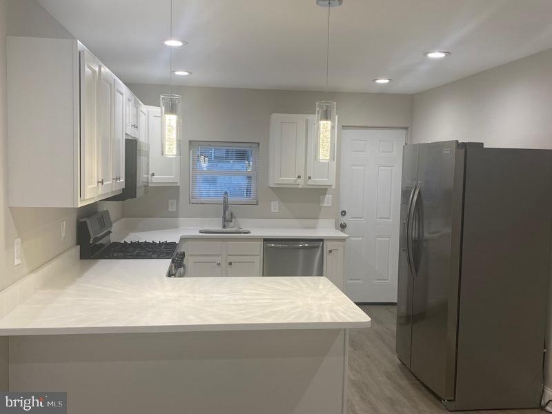 224 North Rose Street Baltimore, MD 21224 - Photo 3 of 14 a kitchen with stainless steel appliances granite countertop a refrigerator a sink and a stove