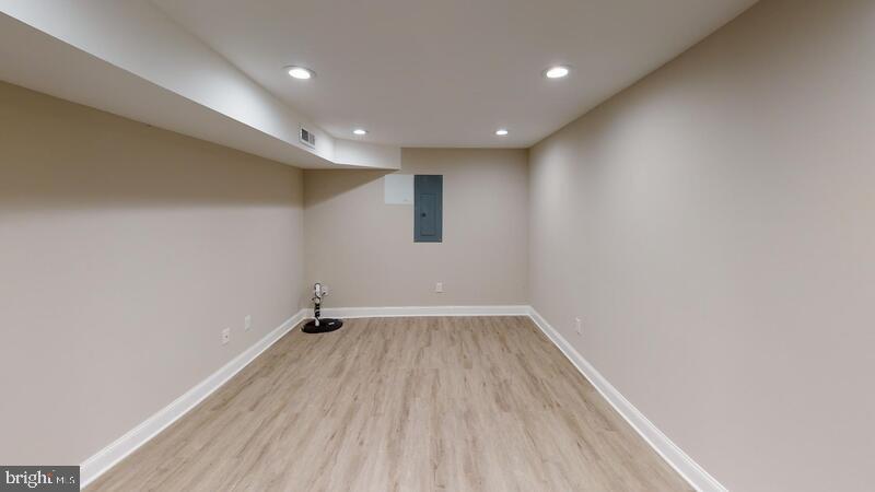 224 North Rose Street Baltimore, MD 21224 - Photo 9 of 14 an empty room with wooden floor and windows