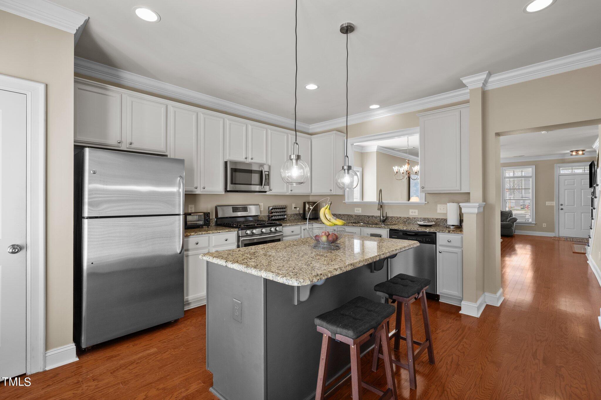 7765 Courtney Estates Drive Raleigh, NC 27617 - Photo 13 of 37 a kitchen with a center island appliances and cabinets