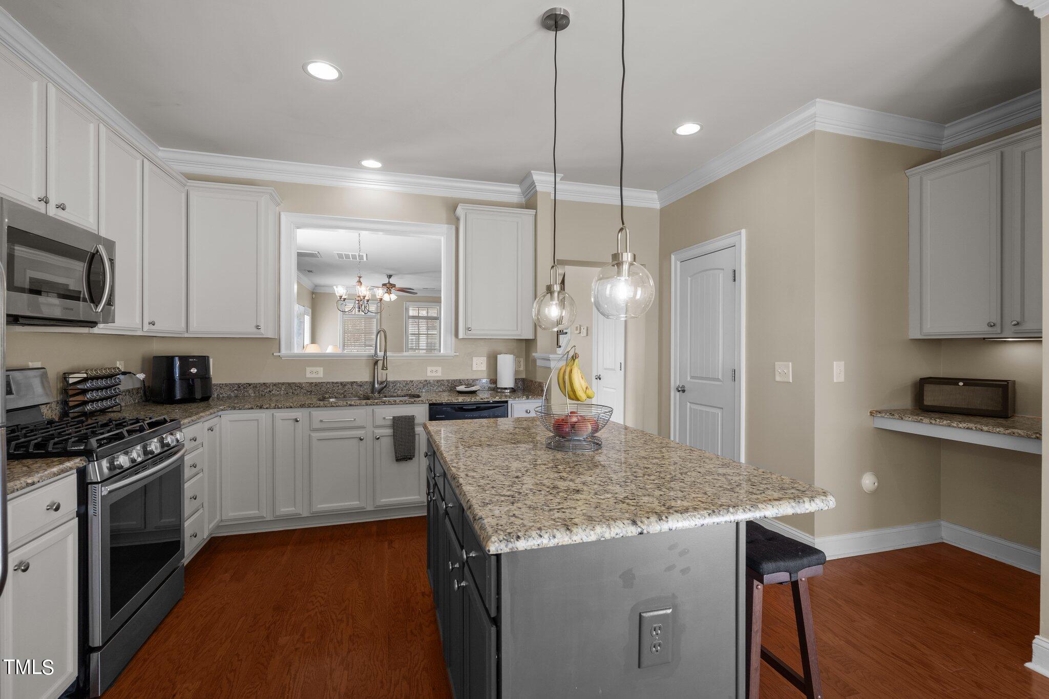 7765 Courtney Estates Drive Raleigh, NC 27617 - Photo 14 of 37 a kitchen with stainless steel appliances granite countertop a sink stove and refrigerator