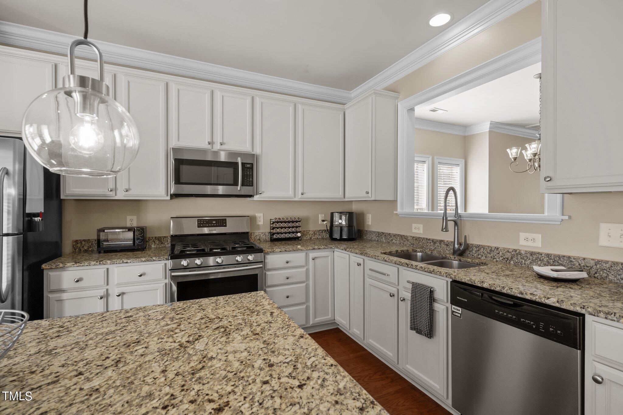 7765 Courtney Estates Drive Raleigh, NC 27617 - Photo 15 of 37 a kitchen with a sink stove and microwave