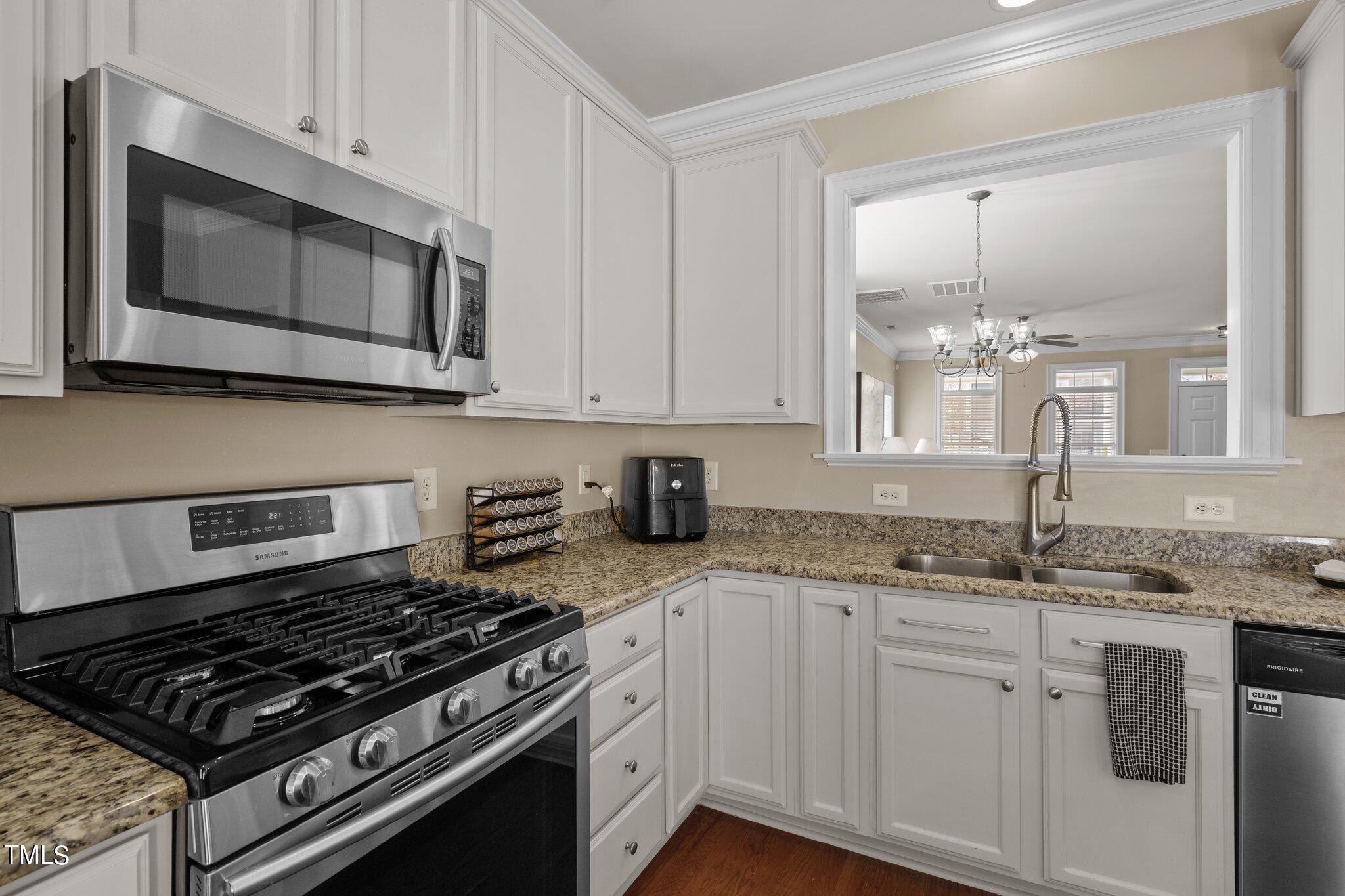 7765 Courtney Estates Drive Raleigh, NC 27617 - Photo 16 of 37 a kitchen with granite countertop a sink stove and microwave